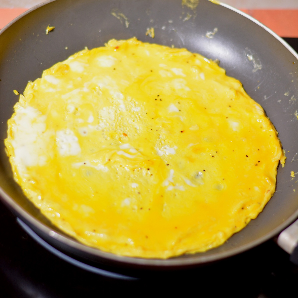 A pan with the eggs starting to cook in a circle.